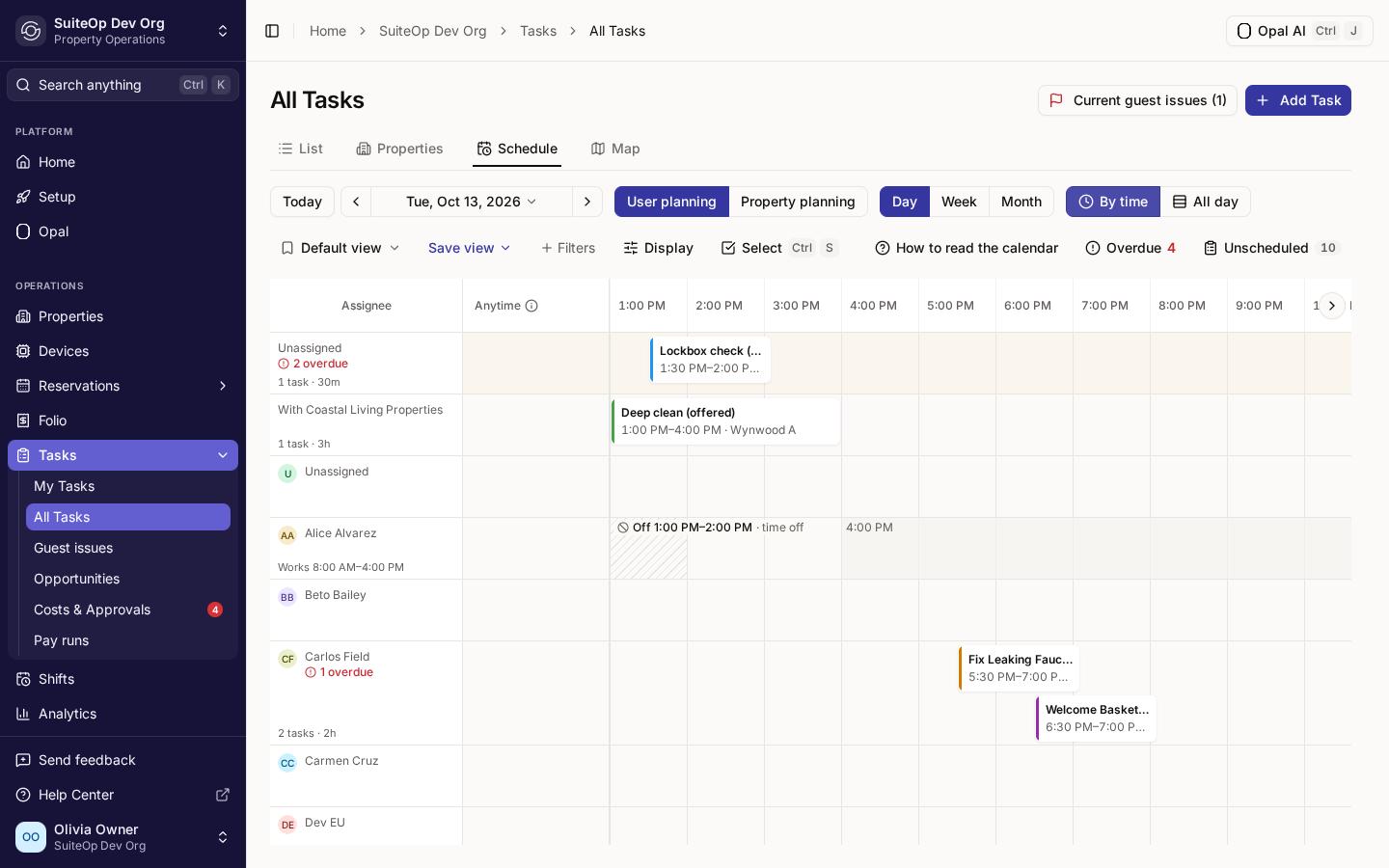 The Schedule tab's Day view in By time layout, with an hourly axis, task cards across their hours, and a person's one-hour time off hatched inside their working hours.